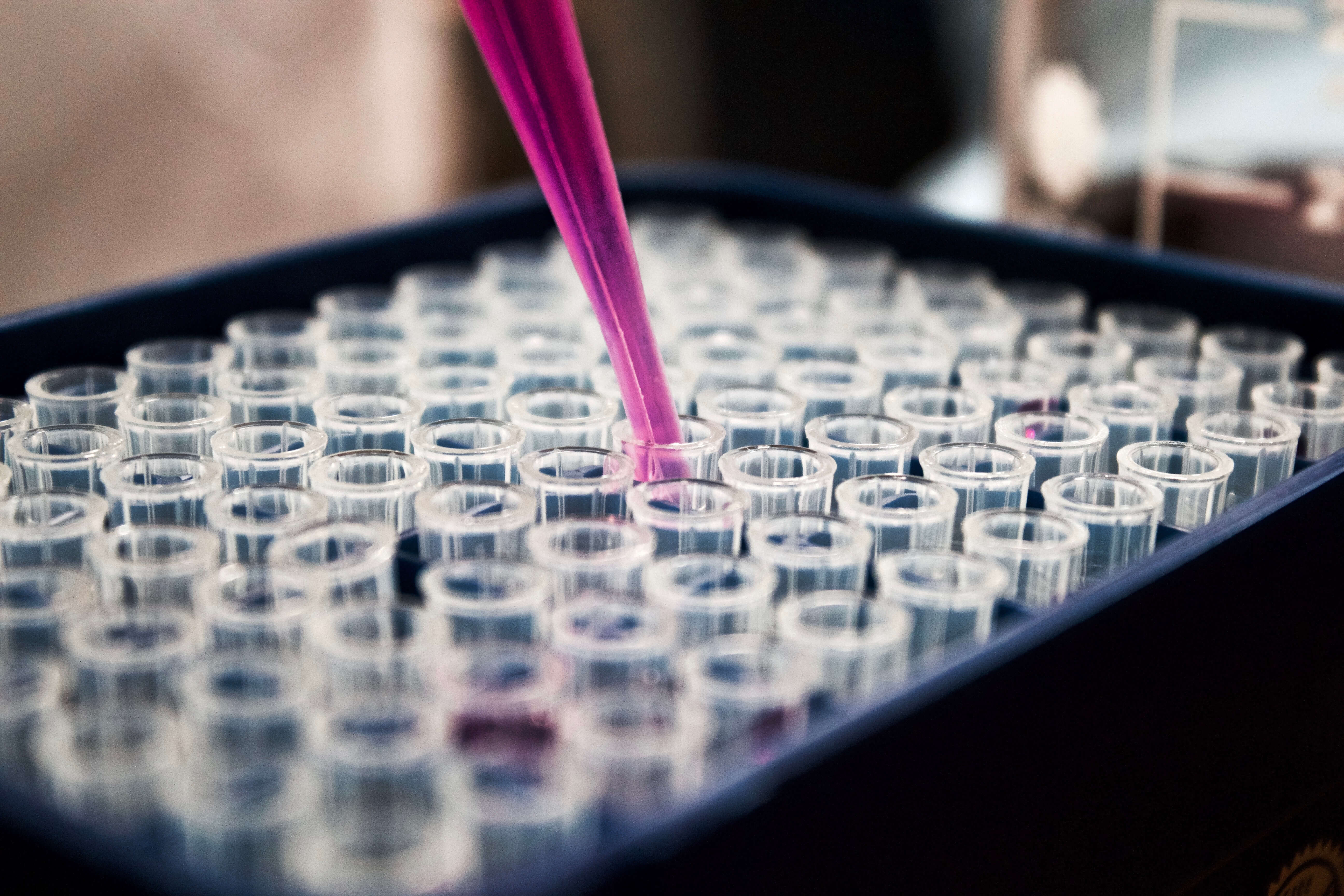 Laboratory test tubes with sample being taken from one